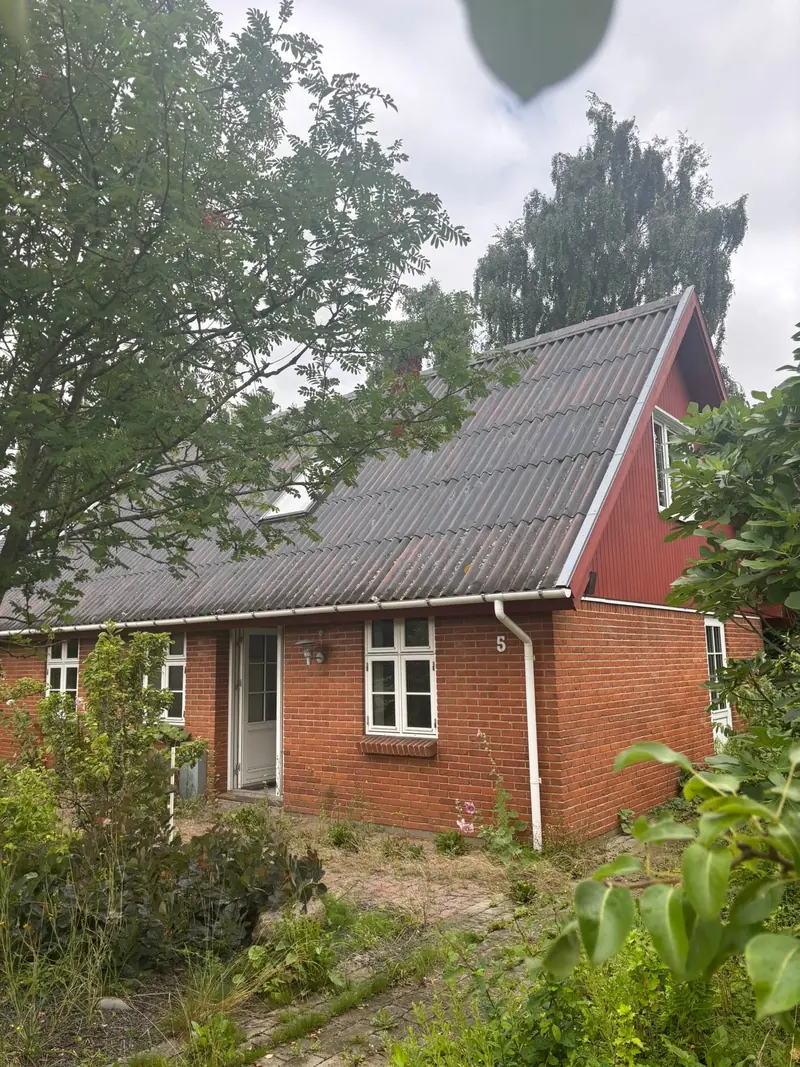 Hus med eternittag før nedrivning